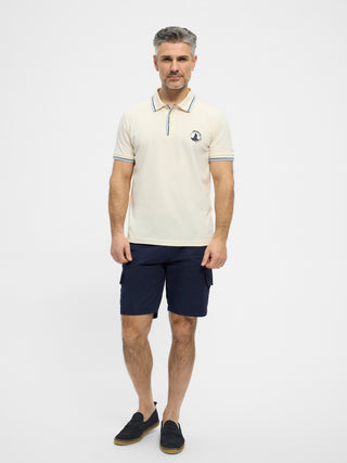 Cremefarvet RedGreen herrepolo med marine- og lyseblå kontraststriber ved krave og ærmer og diskret sejlsportslogo på brystet